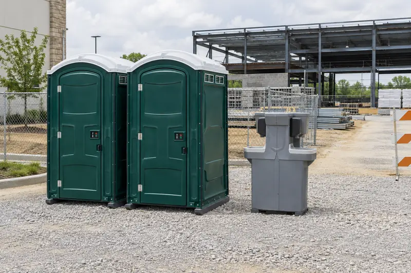 Portable toilets positioned beside an illustrative building project